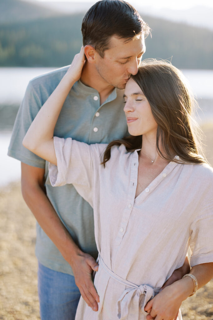 Man kissing woman's head golden hour portrait session.