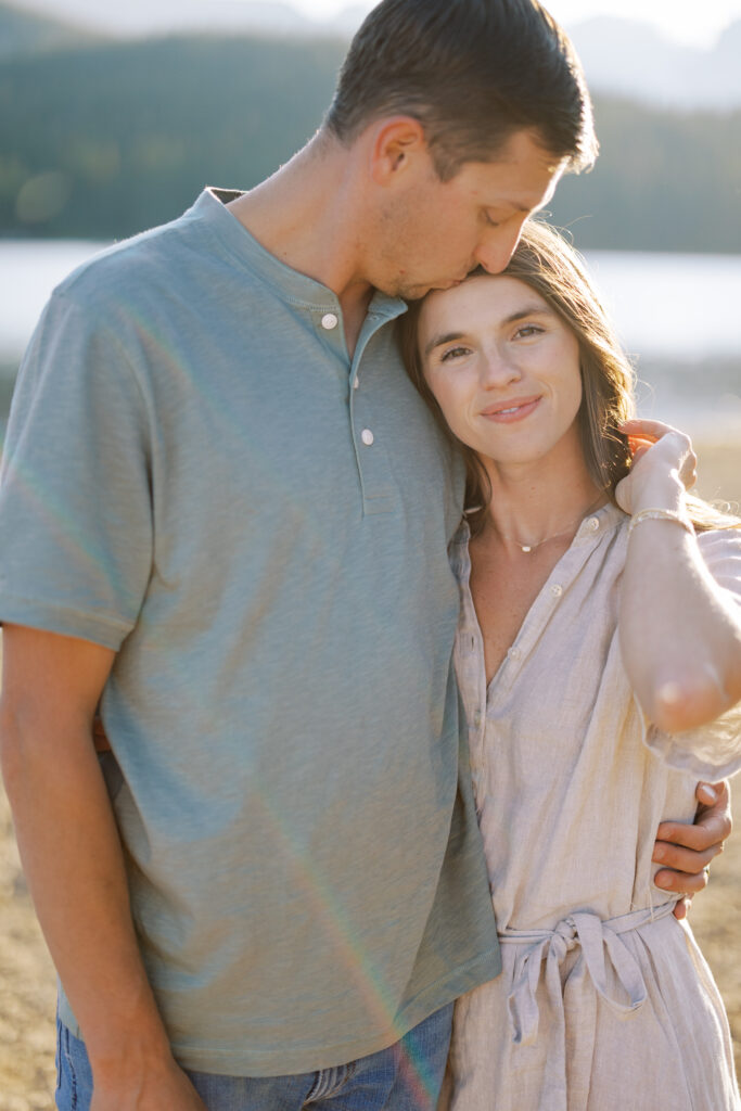 Close-up of couple holding hands by alpine lake near Denver