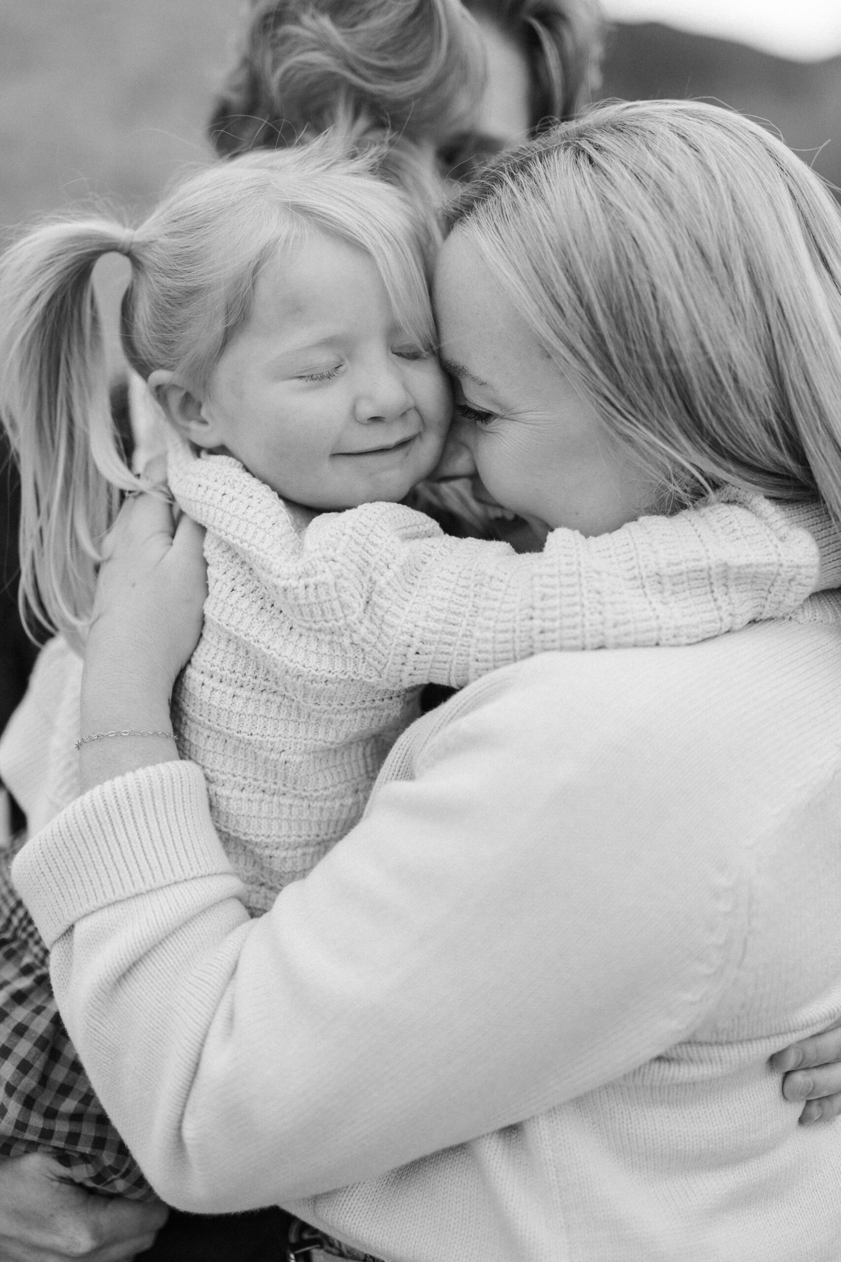 Family embracing with young girl in pigtails